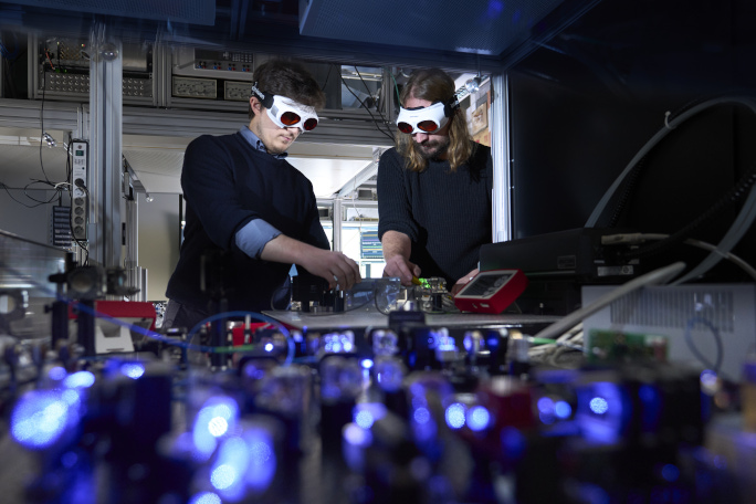 Two people working together in a laboratory with special glasses on