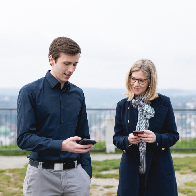 Alina Grüner and Philipp Sleziona looking at their mobile phones